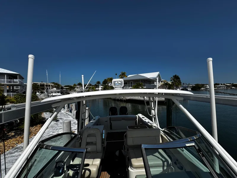 Slide: The Image of 2019 Boston Whaler 270 Vantage boat docked in a marina under clear blue skies. - 32