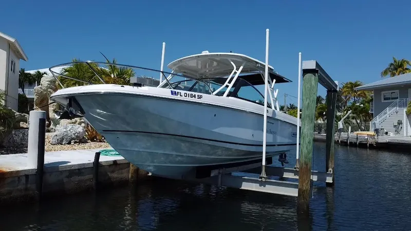 Slide: The Image of 2019 Boston Whaler 270 Vantage boat docked on a lift in a sunny marina. - 8