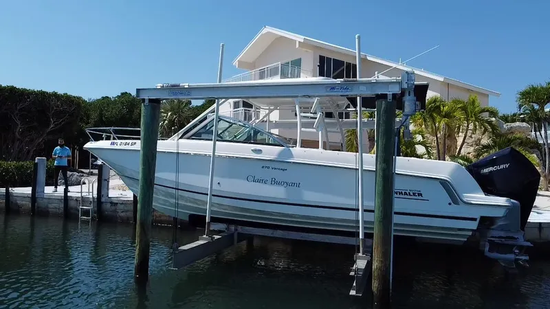 Slide: The Image of 2019 Boston Whaler 270 Vantage boat docked near waterfront home. - 9