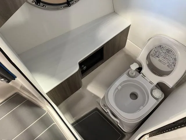 Slide: The Image of 2020 Regal LS6 Surf boat interior with compact marine toilet and storage. - 13