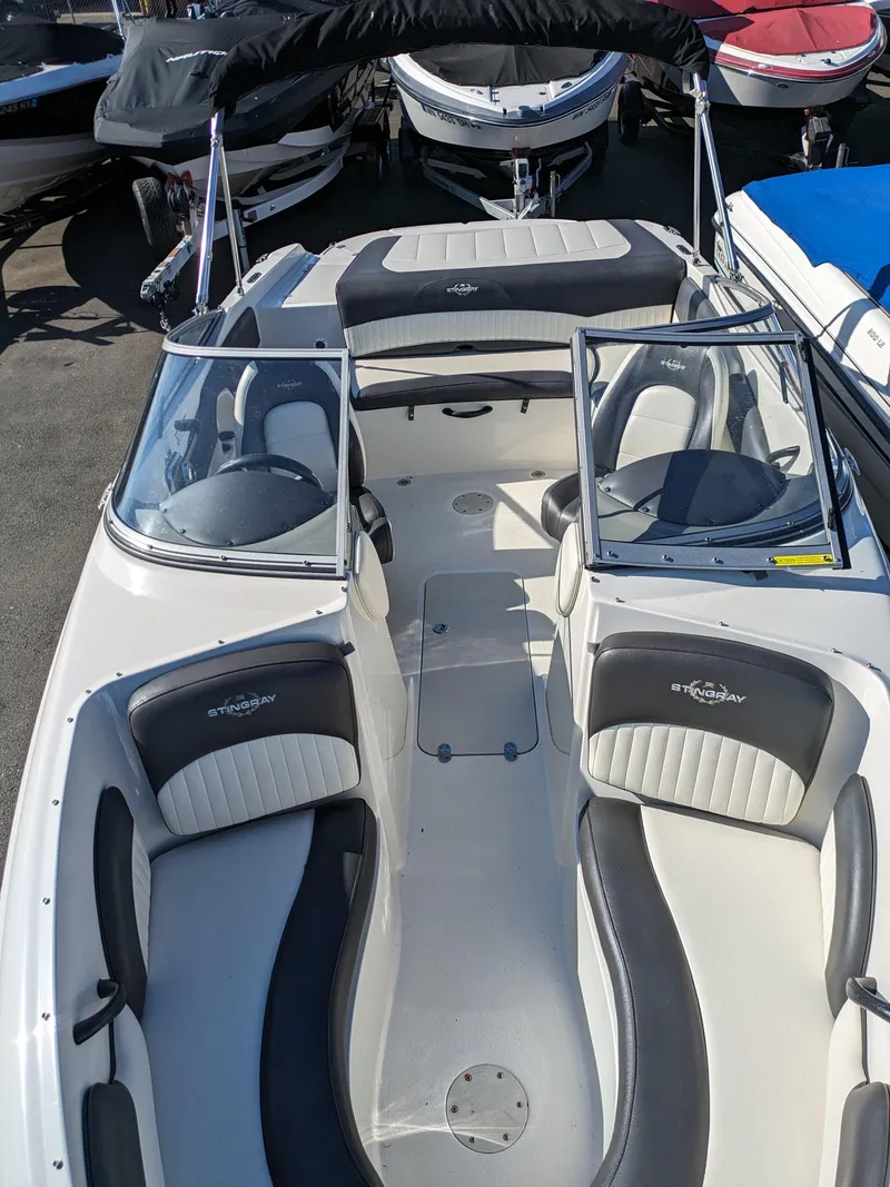 Slide: The Image of 2018 Stingray 208 LS boat with sleek seating and open deck design. - 18