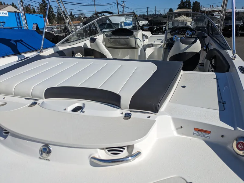 Slide: The Image of 2018 Stingray 208 LS boat interior with white seating and steering console. - 23