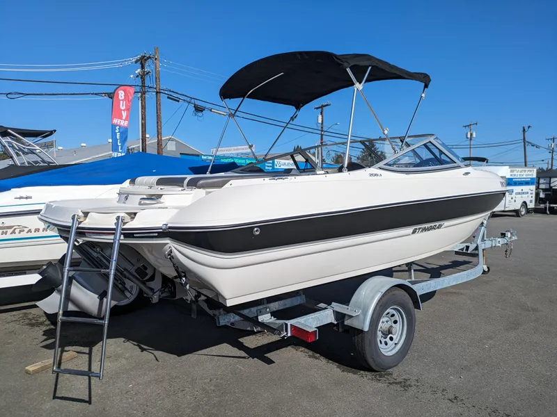 Slide: The Image of 2018 Stingray 208 LS boat on trailer with canopy in outdoor setting. - 3