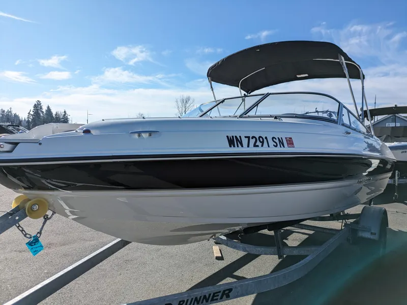 Slide: The Image of 2018 Stingray 208 LS boat on trailer under clear blue sky. - 4
