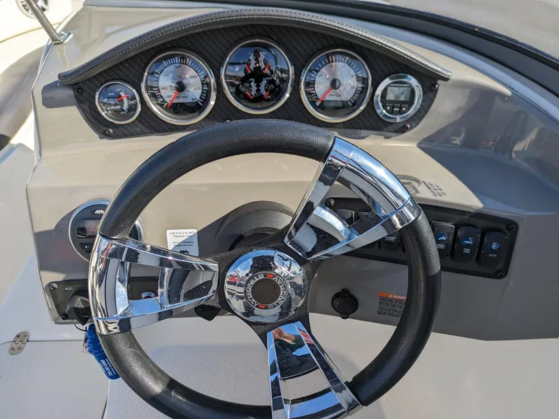 Slide: The Image of Steering wheel and dashboard of 2018 Stingray 208 LS boat, featuring chrome accents and gauges. - 6