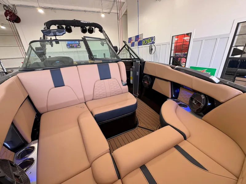 Slide: The Image of 2022 MasterCraft X26 boat interior with tan and black seating, showcasing modern design. - 14