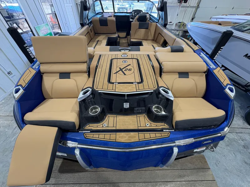 Slide: The Image of 2022 MasterCraft X26 boat interior with tan seating and overhead speakers. - 8