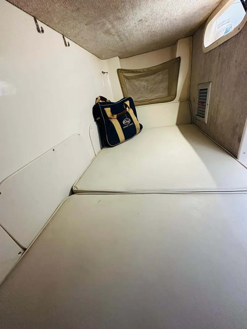 Slide: The Image of 2001 Grady-White Sailfish 282 cabin interior with cushioned seating and storage bag. - 12