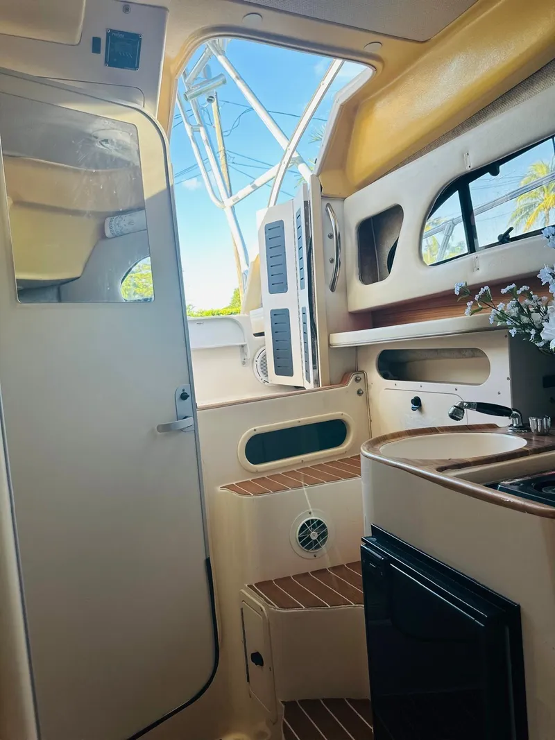 Slide: The Image of Interior of 2001 Grady-White Sailfish 282 boat, featuring compact kitchen and steps. - 5