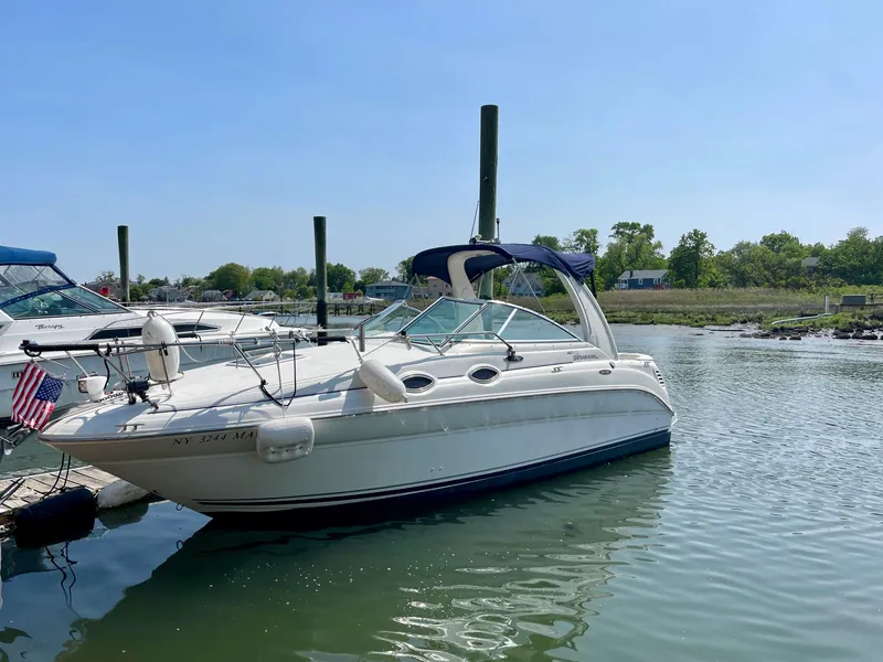 The Image of 2004 Sea Ray 260 Sundancer boat docked in a serene marina setting. - 0