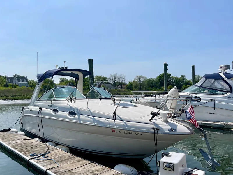Slide: The Image of 2004 Sea Ray 260 Sundancer docked in a marina on a sunny day. - 1
