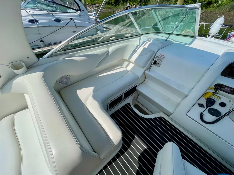 Slide: The Image of Interior view of 2004 Sea Ray 260 Sundancer boat with white seating and control panel. - 4