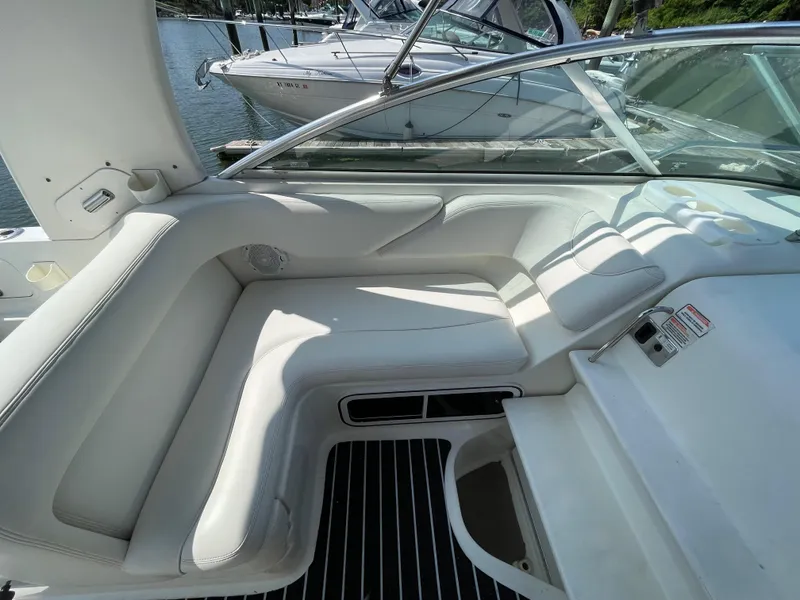 Slide: The Image of Interior seating of 2004 Sea Ray 260 Sundancer boat, featuring white upholstery and sleek design. - 5
