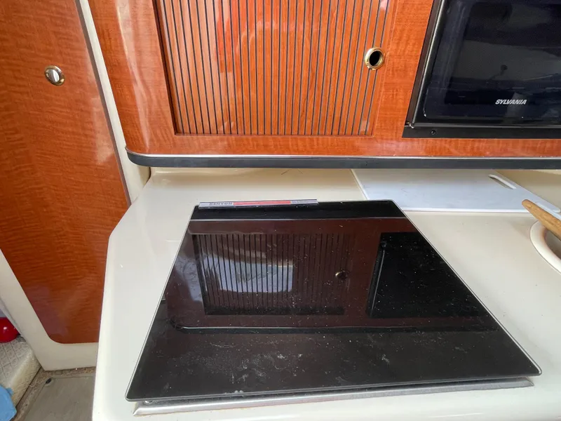 Slide: The Image of Interior of 2004 Sea Ray 260 Sundancer with stove and wooden cabinetry. - 8