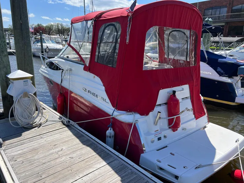 Slide: The Image of 2010 Regal 2565 Window Express boat with red canopy docked at marina. - 1