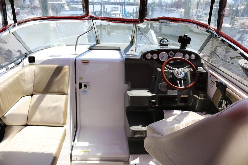 Slide: The Image of 2010 Regal 2565 Window Express boat interior with steering wheel and seating area. - 14