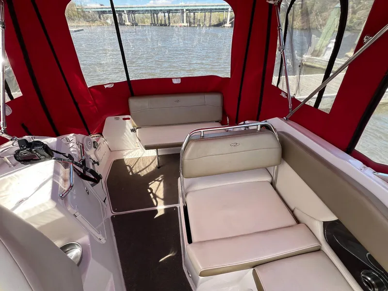 Slide: The Image of Interior of 2010 Regal 2565 Window Express boat with red canopy and beige seating. - 16