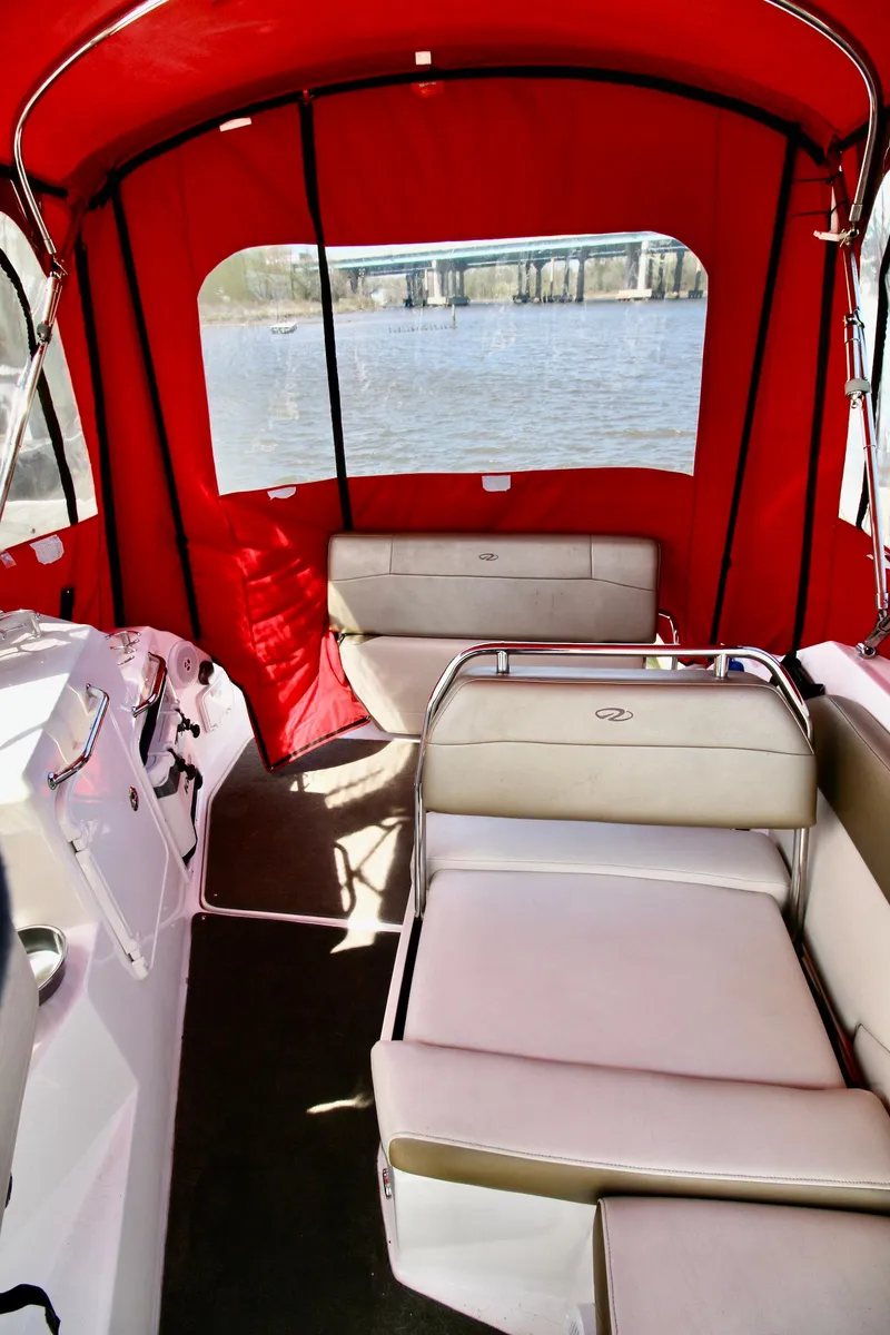 Slide: The Image of 2010 Regal 2565 Window Express boat interior with red canopy and beige seating. - 17
