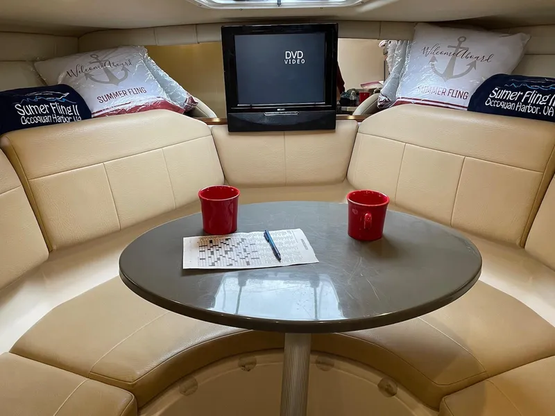 Slide: The Image of Interior of 2010 Regal 2565 Window Express boat with table, seating, and TV. - 20