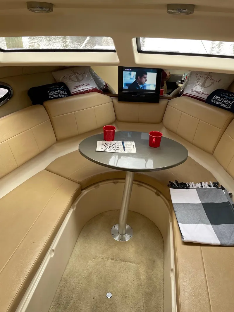 Slide: The Image of Cozy interior of 2010 Regal 2565 Window Express boat with seating, table, and TV. - 21