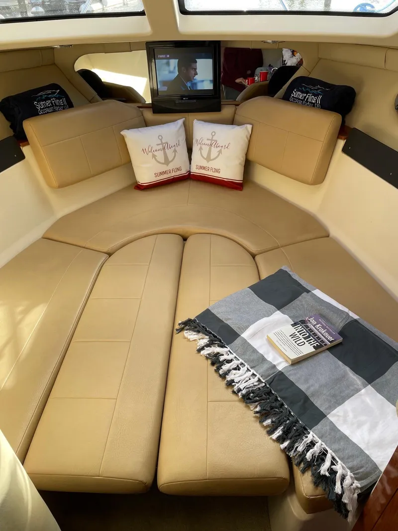 Slide: The Image of Interior of 2010 Regal 2565 Window Express boat with cozy seating and decorative pillows. - 22