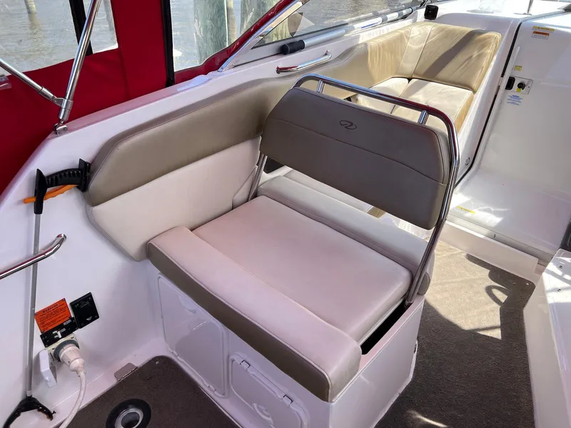 Slide: The Image of 2010 Regal 2565 Window Express boat interior with beige seating and red canopy. - 5