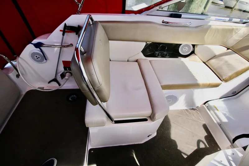 Slide: The Image of 2010 Regal 2565 Window Express boat interior with beige seating and red accents. - 8