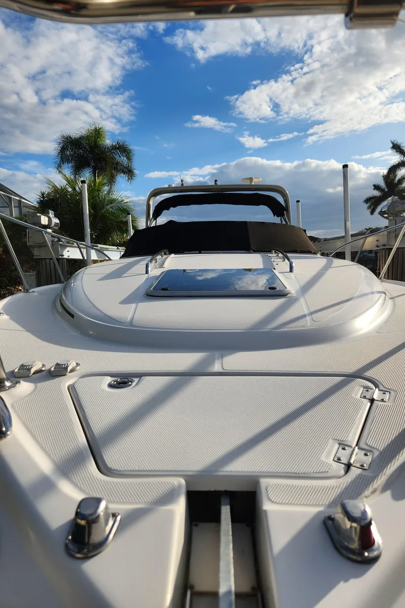 Slide: The Image of 2004 Chaparral Signature 290 boat under a blue sky with palm trees. - 10