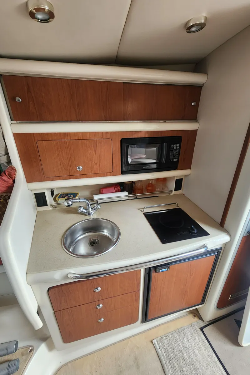Slide: The Image of 2004 Chaparral Signature 290 boat kitchenette with sink, microwave, and stove. - 12