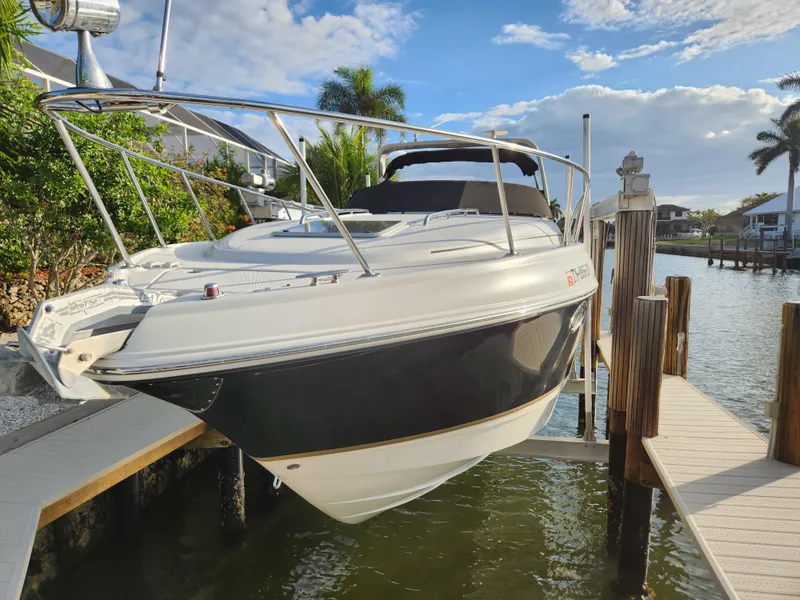 Slide: The Image of 2004 Chaparral Signature 290 boat docked by waterfront, sunny day, palm trees in background. - 3