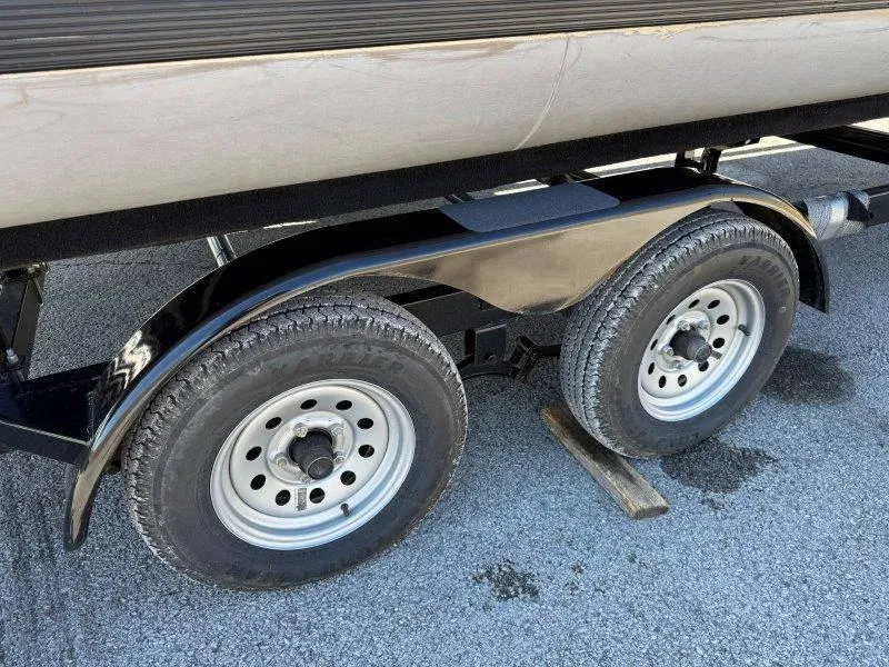Slide: The Image of 2022 Tahoe LTZ VRB 2485 trailer wheels on pavement, featuring dual axles and metal fenders. - 21