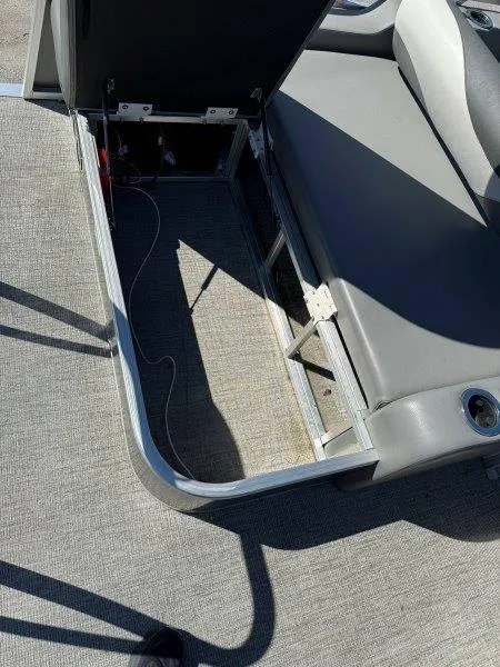 Slide: The Image of Open storage compartment on 2022 Tahoe LTZ VRB 2485 boat with gray seating. - 45
