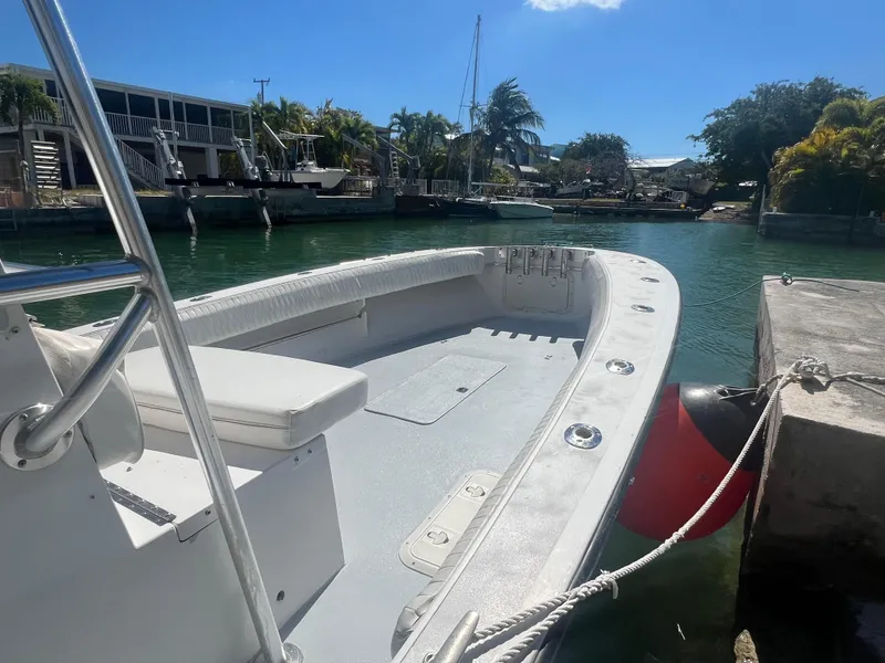 Slide: The Image of 1984 SeaVee 25 boat docked in a sunny marina, featuring spacious seating and sleek design. - 4