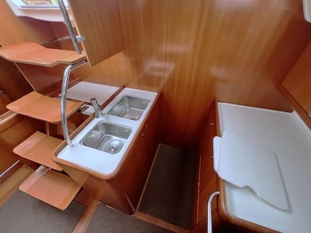 Slide: The Image of Interior of 2007 Beneteau Oceanis 46 yacht, featuring wooden cabinetry and dual sinks. - 21