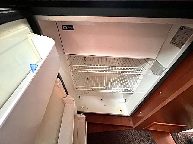 Slide: The Image of Empty refrigerator inside 2007 Beneteau Oceanis 46 yacht, featuring wire shelves. - 23