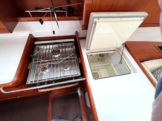 Slide: The Image of Beneteau Oceanis 46 (2007) yacht kitchen with stove and storage compartments. - 24