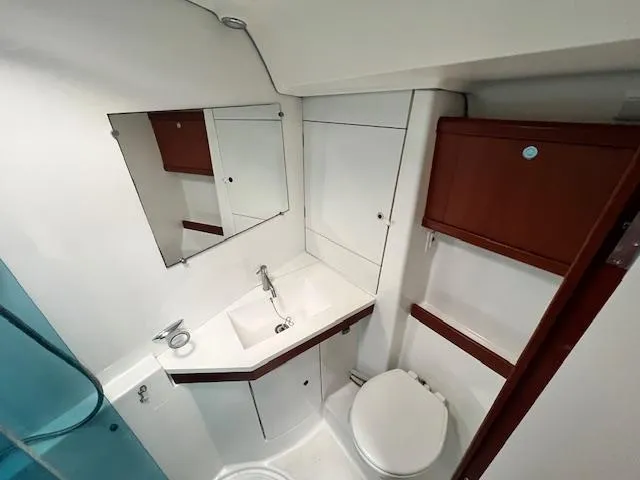 Slide: The Image of Bathroom interior of 2007 Beneteau Oceanis 46 yacht, featuring sink, mirror, and storage cabinets. - 32