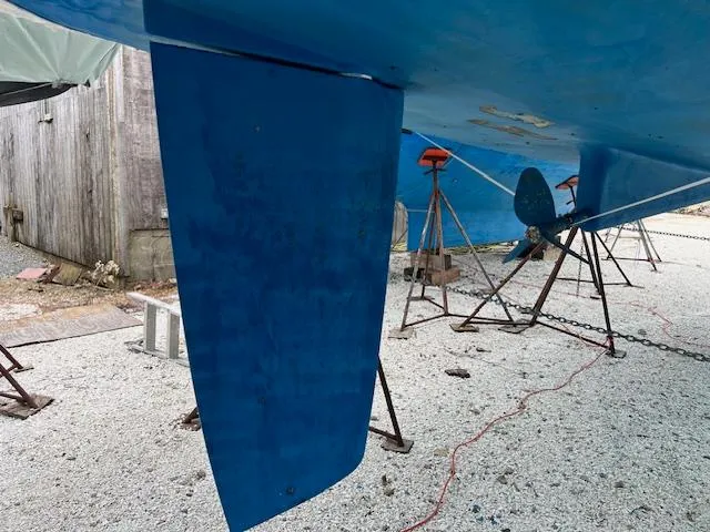 Slide: The Image of Beneteau Oceanis 46 (2007) sailboat hull and keel on dry dock, blue paint visible. - 9