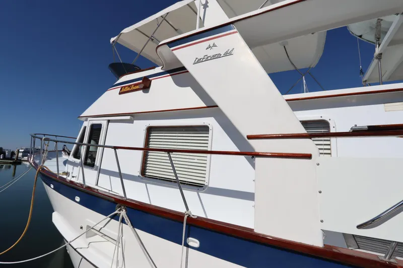 Slide: The Image of 1985 DeFever 44 Trawler boat docked, showcasing classic design and white exterior. - 11