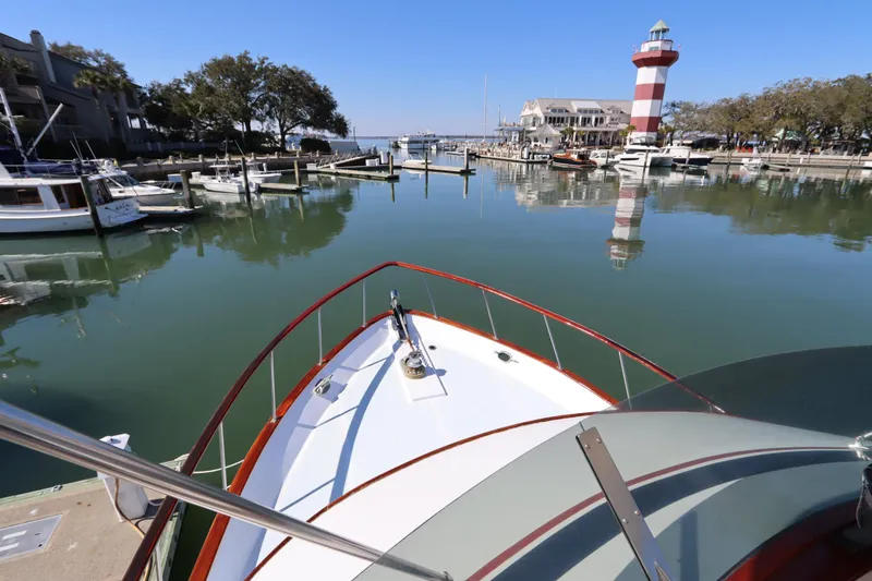 Slide: The Image of DeFever 44 Trawler 1985 in marina with lighthouse and calm waters. - 18