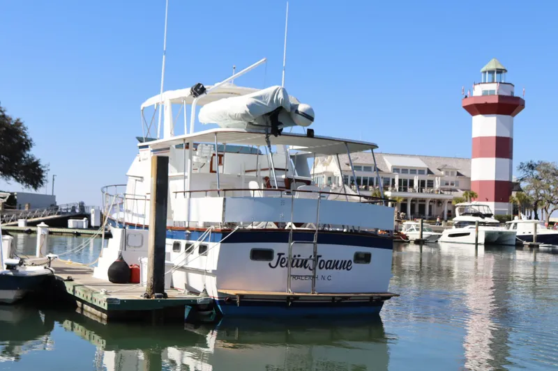Slide: The Image of 1985 DeFever 44 Trawler docked near a lighthouse in a marina. - 2