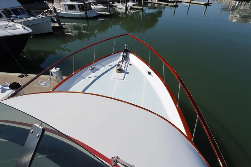 Slide: The Image of 1985 DeFever 44 Trawler docked in a marina, showcasing its bow and railing. - 20
