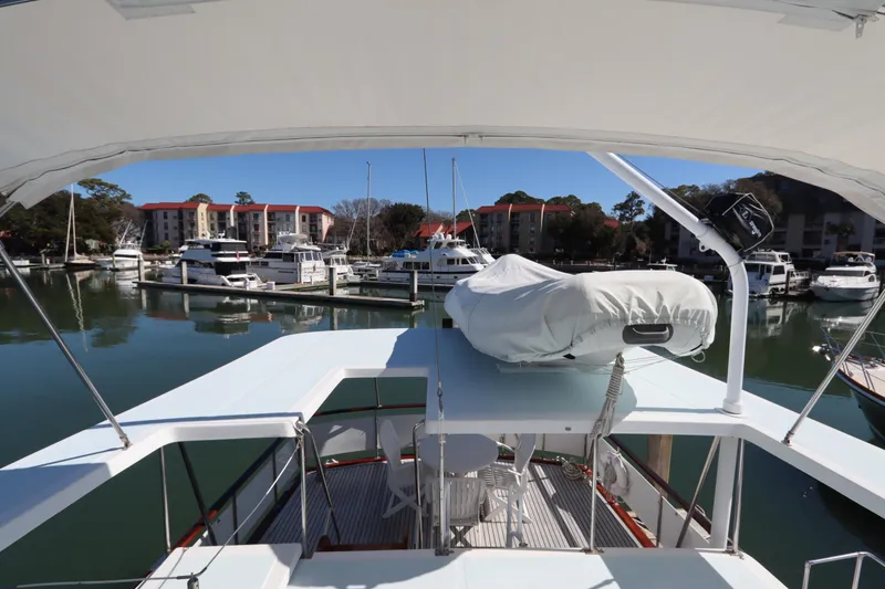 Slide: The Image of 1985 DeFever 44 Trawler docked in a marina with surrounding boats and buildings. - 21