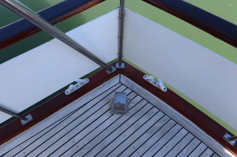 Slide: The Image of DeFever 44 Trawler 1985 deck corner with wooden flooring and metal railings. - 29