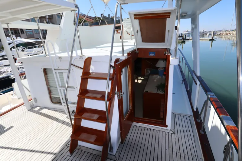 Slide: The Image of 1985 DeFever 44 Trawler deck with wooden stairs and open cabin door. - 30
