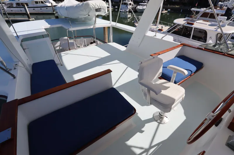 Slide: The Image of 1985 DeFever 44 Trawler flybridge with seating and helm chair, docked at marina. - 33