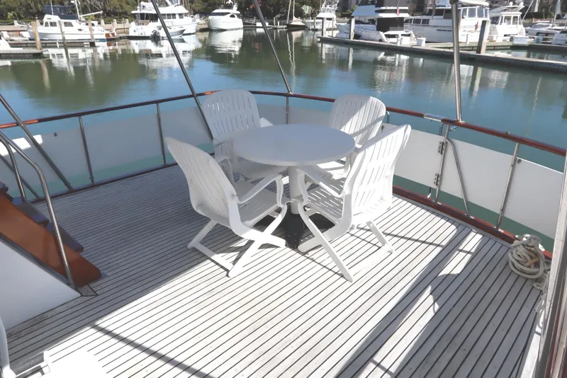 Slide: The Image of Deck of 1985 DeFever 44 Trawler with white table and chairs, marina view. - 35