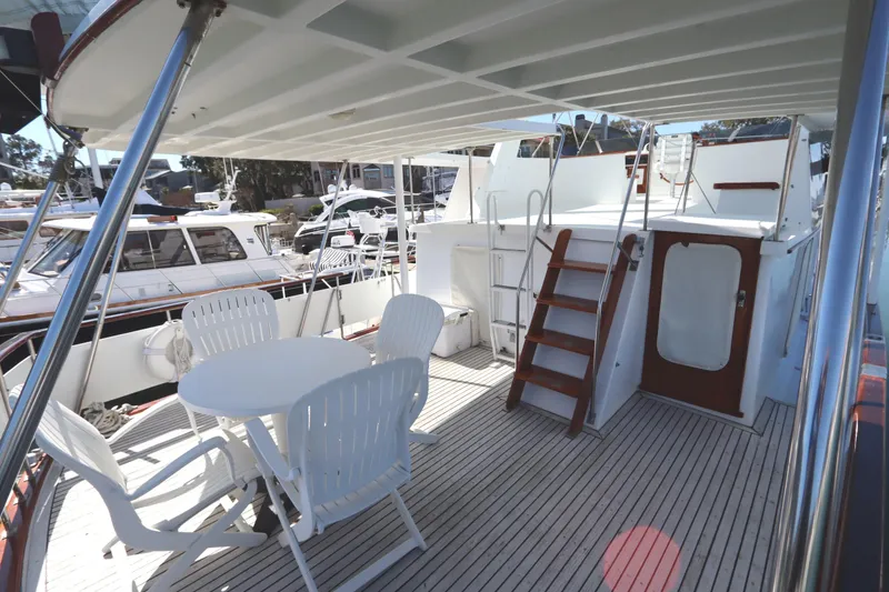 Slide: The Image of 1985 DeFever 44 Trawler deck with seating area and wooden stairs. - 36