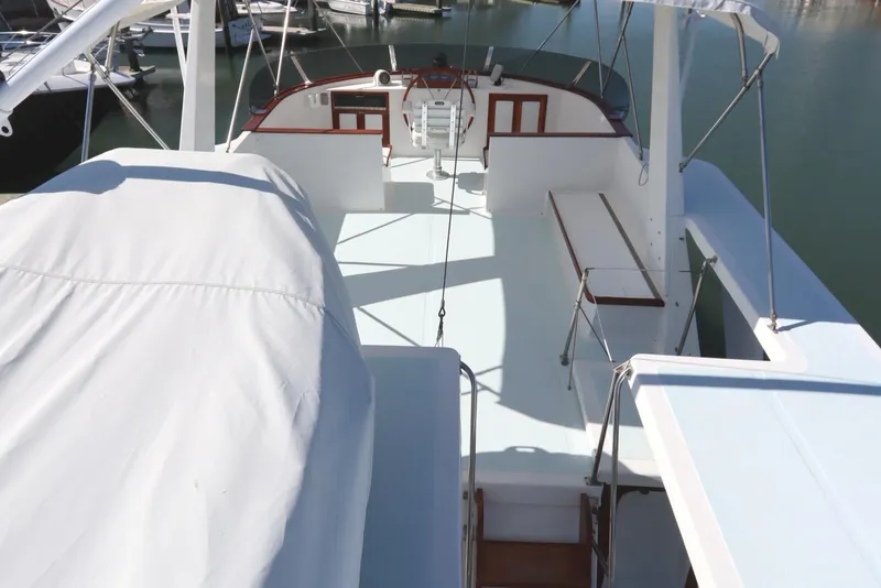 Slide: The Image of 1985 DeFever 44 Trawler flybridge with seating, docked in a marina. - 41