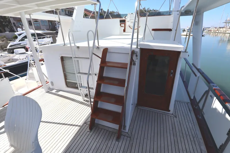 Slide: The Image of 1985 DeFever 44 Trawler deck with wooden stairs and marina view. - 43